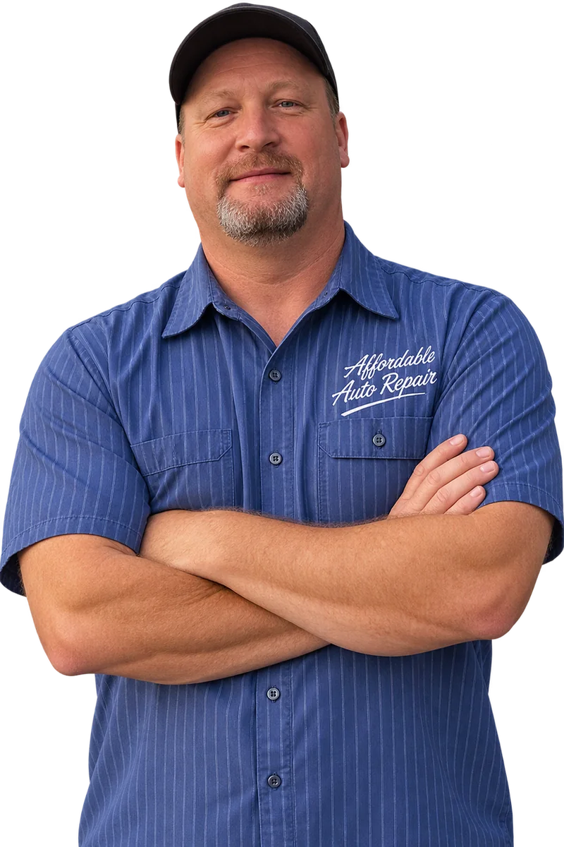 Smoky Gaskins, owner of Affordable Auto Repair, arms crossed in a work shirt with the shop name on it