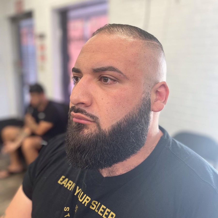 Full dark beard lined up clean, front view, La Barberia