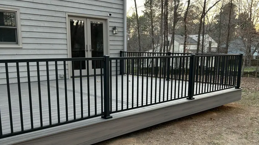 Gray composite deck with a black rail and French doors on a gray-sided home