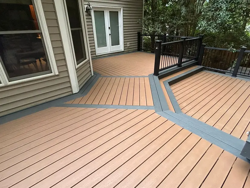 Composite deck with tan boards, a gray picture-frame border and a black rail