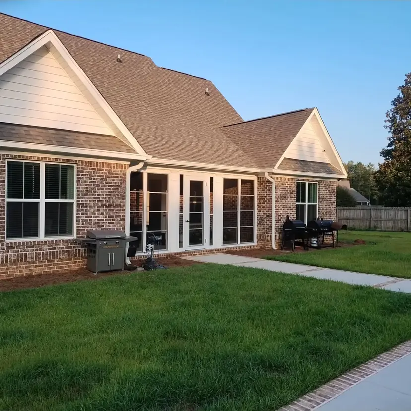 Brick home with a covered lanai and French doors facing a lawn