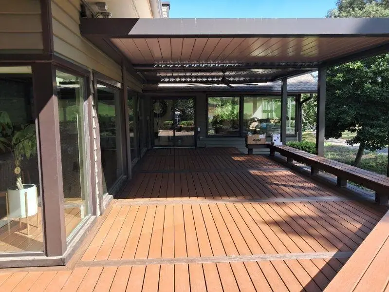 Louvered pergola roof attached to the house over a composite deck