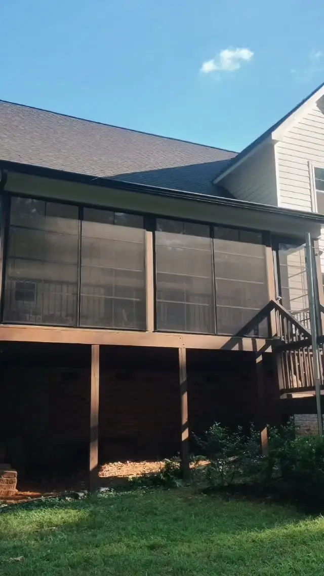 Two-story screened porch on the back of a home with a lower level below