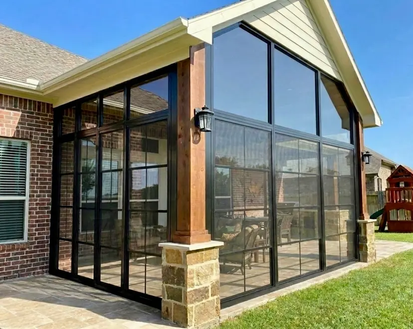 Glass gable sunroom with a cedar post beside a brick home