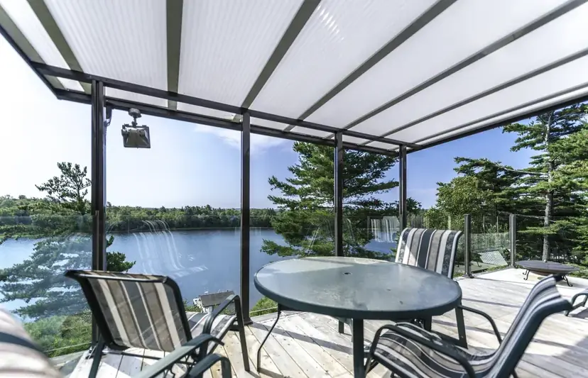 Sunspace acrylic patio cover over a deck with a lake view