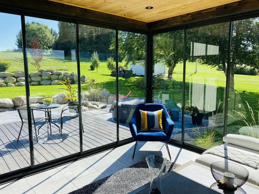 NovaSun Horizon Plus glass wall closing in a garden room