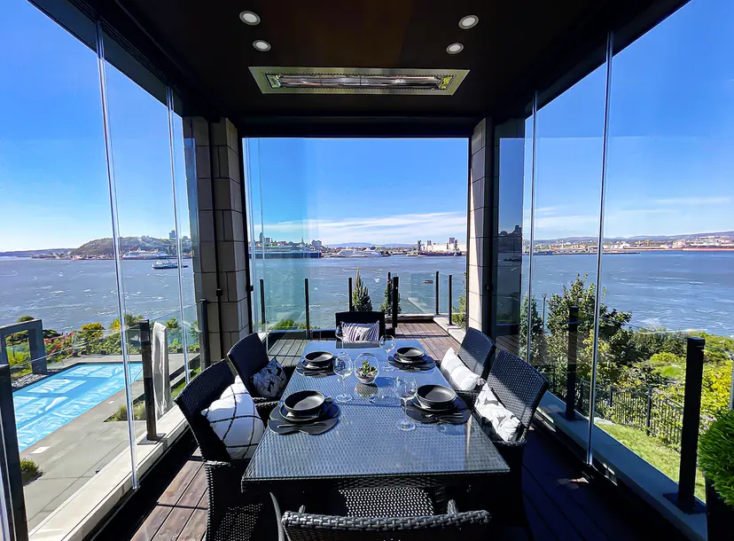 Sunspace NovaSun Horizon sliding glass walls open on a terrace above the water