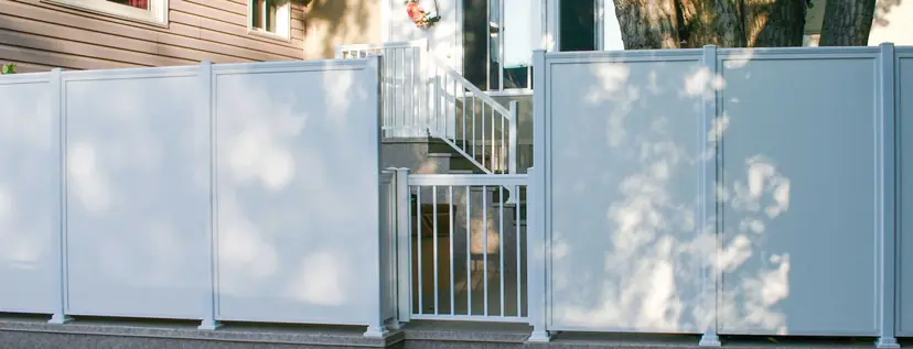 Sunspace white aluminum privacy fence along a property line. Sunspace aluminum privacy fence