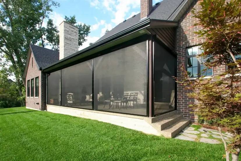 Sunspace retractable screen enclosing a porch on a brick home