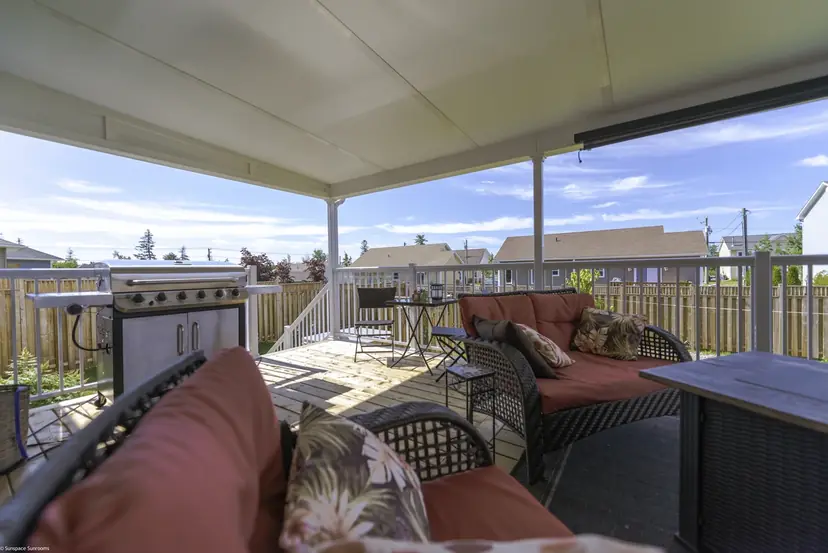 Solid insulated Sunspace patio cover over a deck with a grill and seating