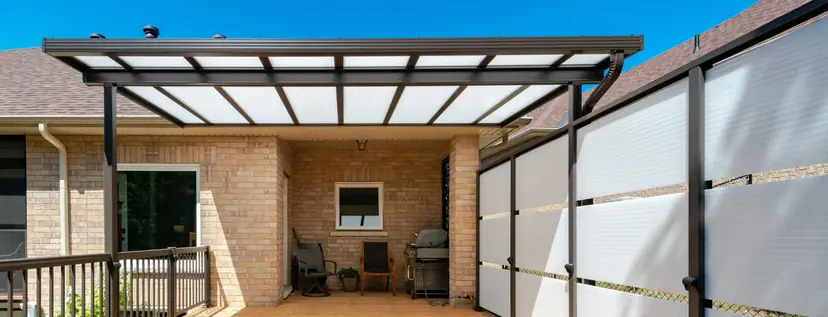 Sunspace Sunwall privacy wall beside an acrylic patio cover on a brick home
