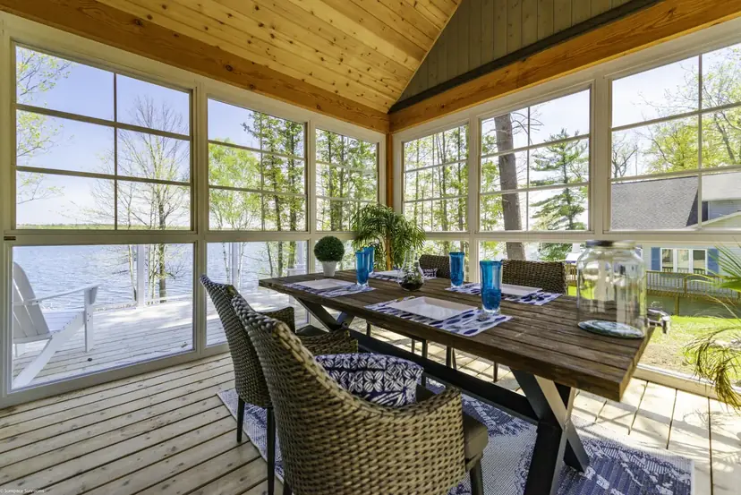 Enclosed porch with Sunspace WeatherMaster windows set up as a dining room